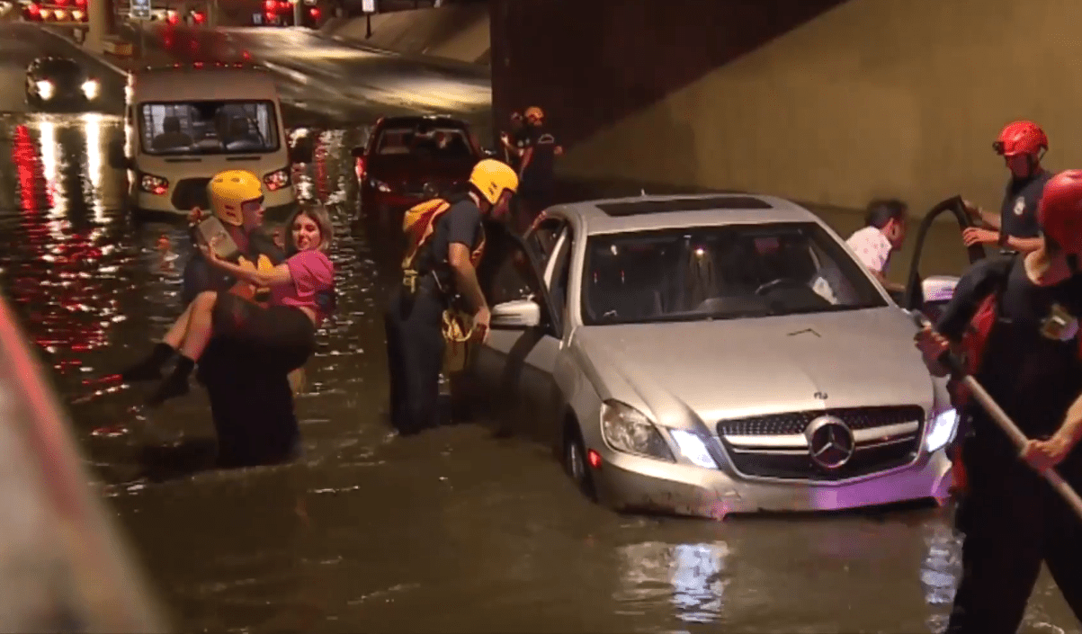 High waters trap a car underneath a bridge