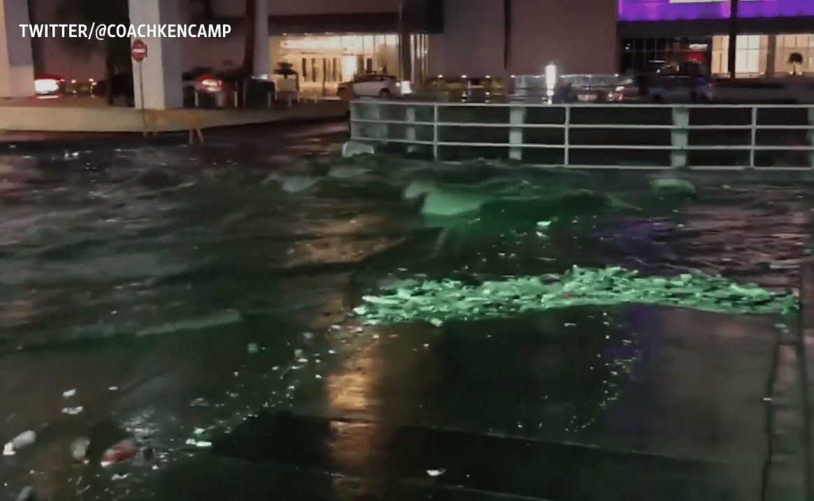 Water floods down the street and into an underpass.