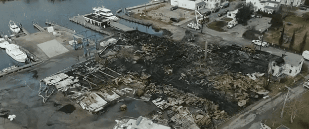 An aerial view of the marina warehouse shows rubble after the fire.