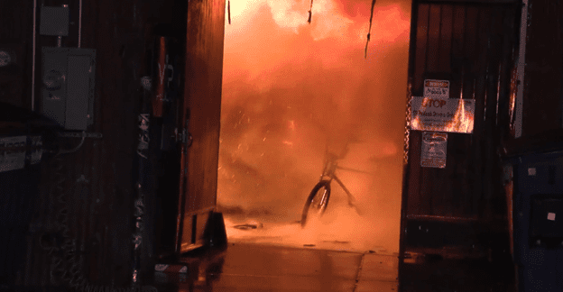 Fire engulfs a pedicab during a warehouse fire.