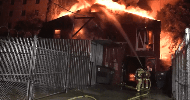 Pedicab warehouse is shown with flames escaping the roof.