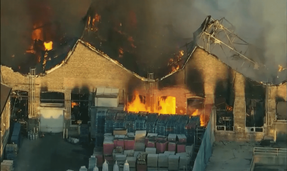 Image: large manufacturing facility burning from the insude.