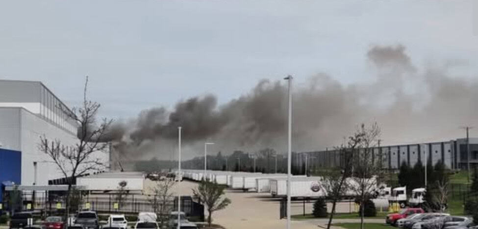 Thick black smoke fills the sky